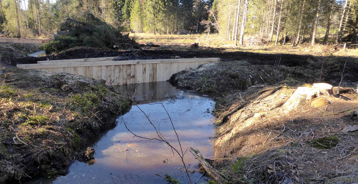 La palissade en bois sert à retenir assez d’eau dans le marais.