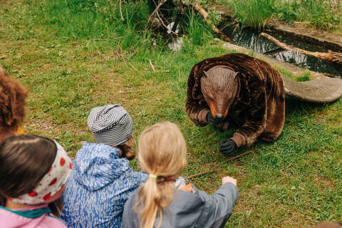 Kinder schauen dem Biber beim Fressen zu